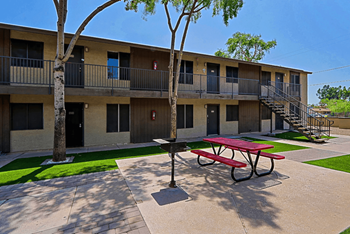 A red picnic table is in front of a building with balconies at Sahuaro West, Phoenix